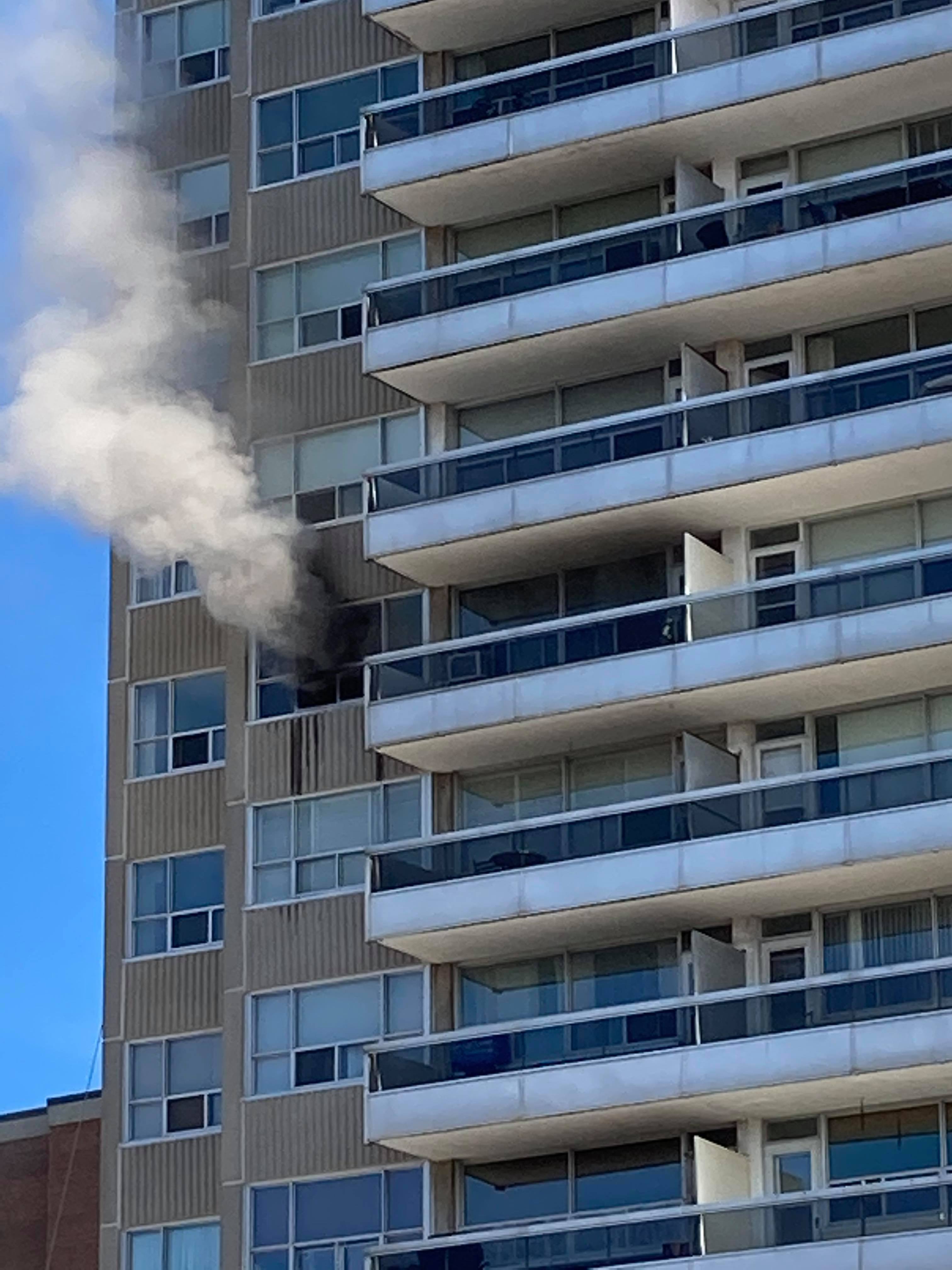 Smoke pours out of a broken window | A Bronte high rise was evacuated after fire destroyed a 9th floor unit March 15. | Kate Boland